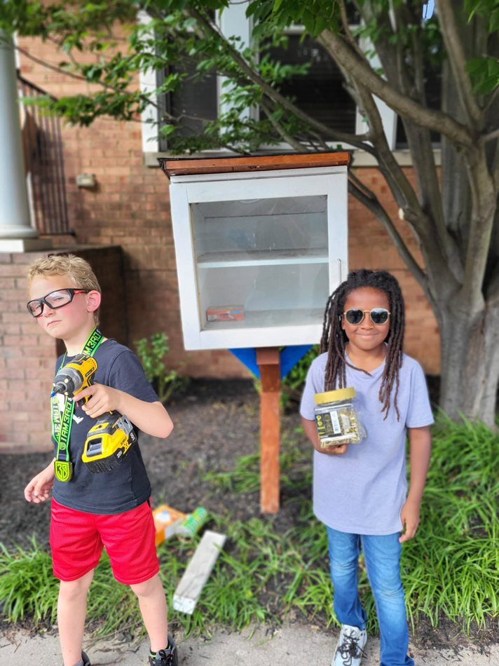 Standing beside a small outdoor library